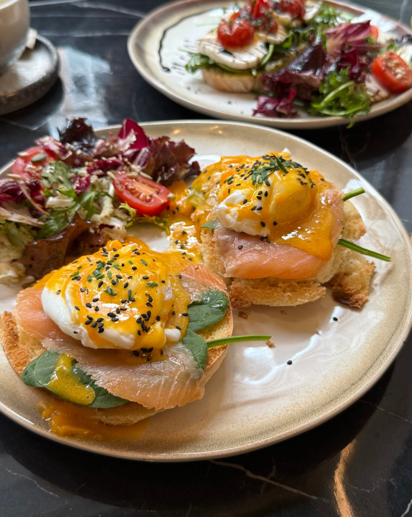 Benedict XO servido con salmón ahumado y ensalada de burrata en XO Brunch