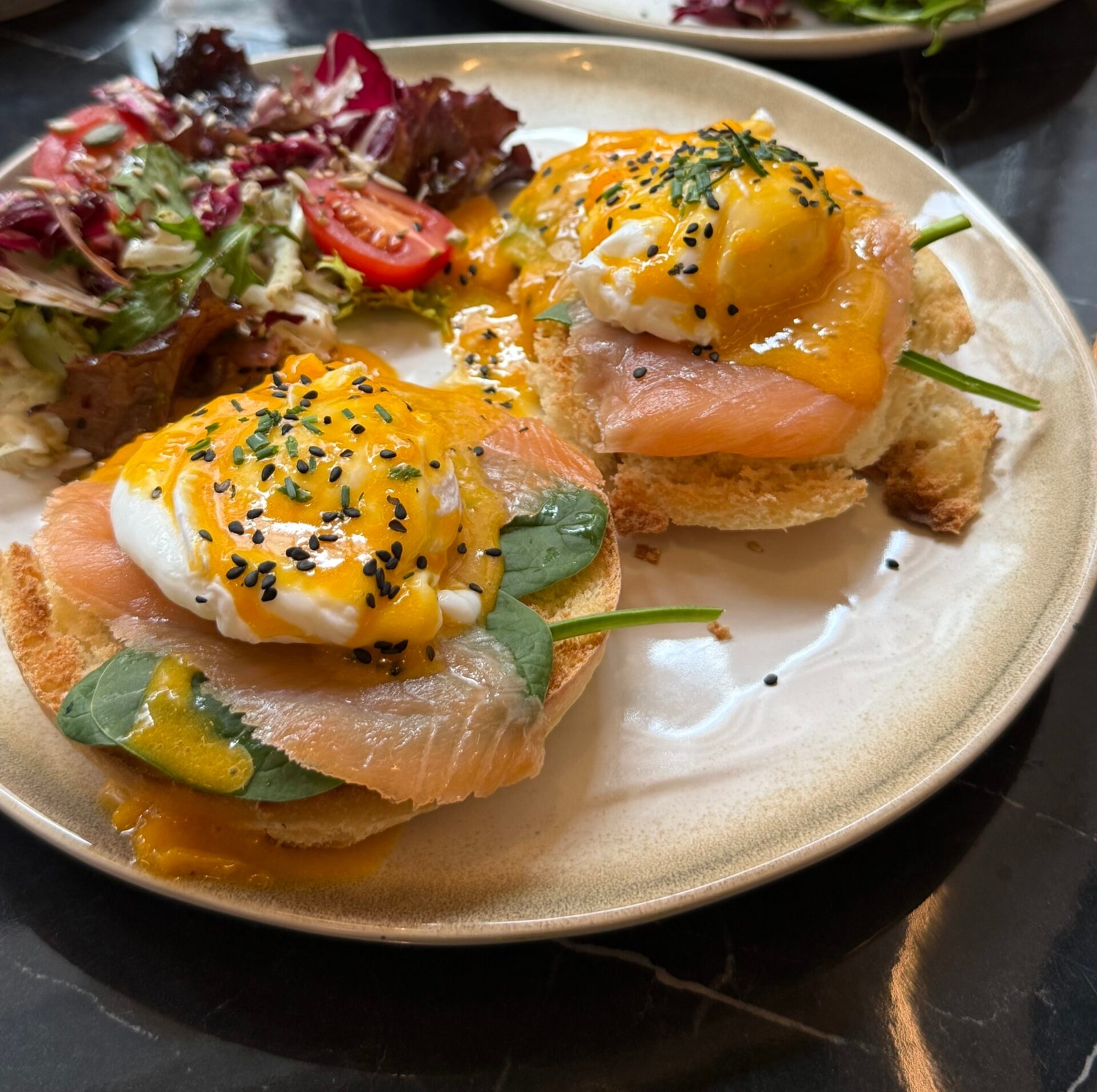 Benedict XO servido con salmón ahumado y ensalada de burrata en XO Brunch